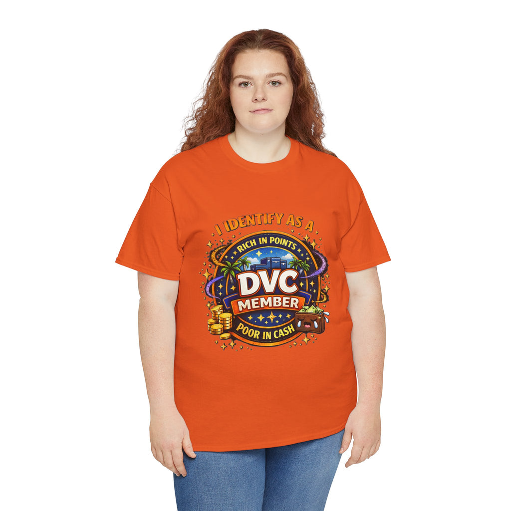 A woman with red hair wearing a bright orange graphic t-shirt and blue jeans, standing against a plain white background. The t-shirt features a colorful graphic with the text 'I IDENTIFY AS A DVC MEMBER RICH IN POINTS POOR IN CASH' and a casino-themed design.