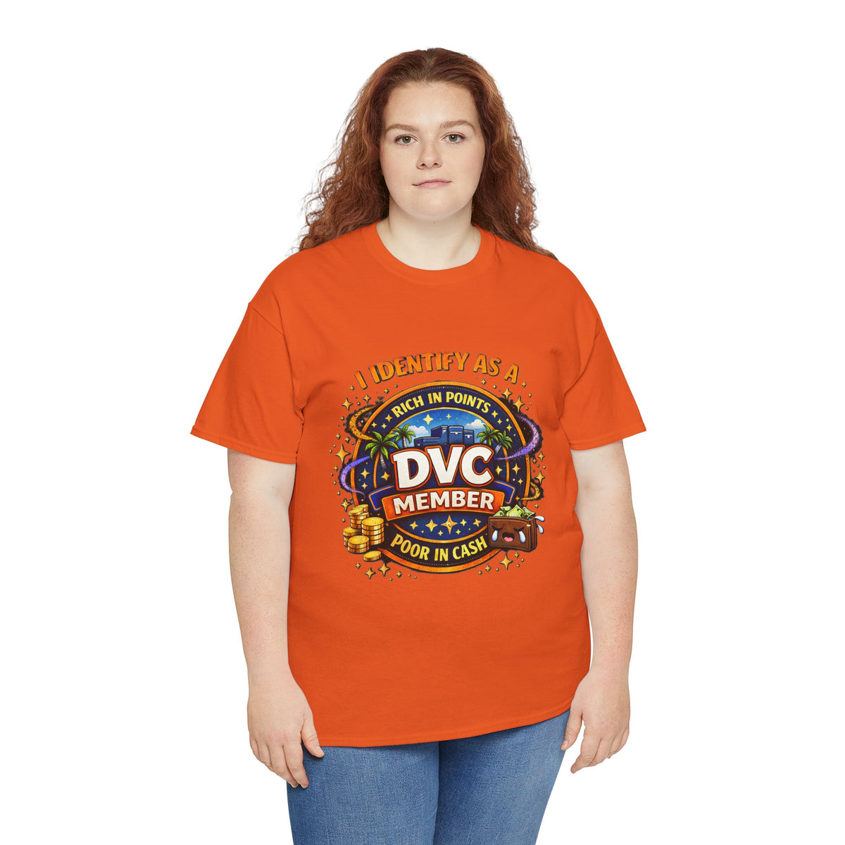 A woman with red hair wearing a bright orange graphic t-shirt and blue jeans, standing against a plain white background. The t-shirt features a colorful graphic with the text 'I IDENTIFY AS A DVC MEMBER RICH IN POINTS POOR IN CASH' and a casino-themed design.