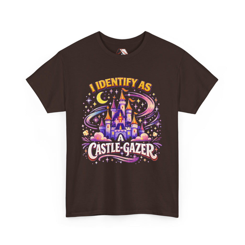 A dark brown short-sleeve t-shirt with a colorful graphic print on the front. The graphic features a whimsical castle under a crescent moon and stars, with the text 'I IDENTIFY AS A CASTLE-GAZER' in stylized fonts.