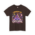 A dark brown short-sleeve t-shirt with a colorful graphic print on the front. The graphic features a whimsical castle under a crescent moon and stars, with the text 'I IDENTIFY AS A CASTLE-GAZER' in stylized fonts.