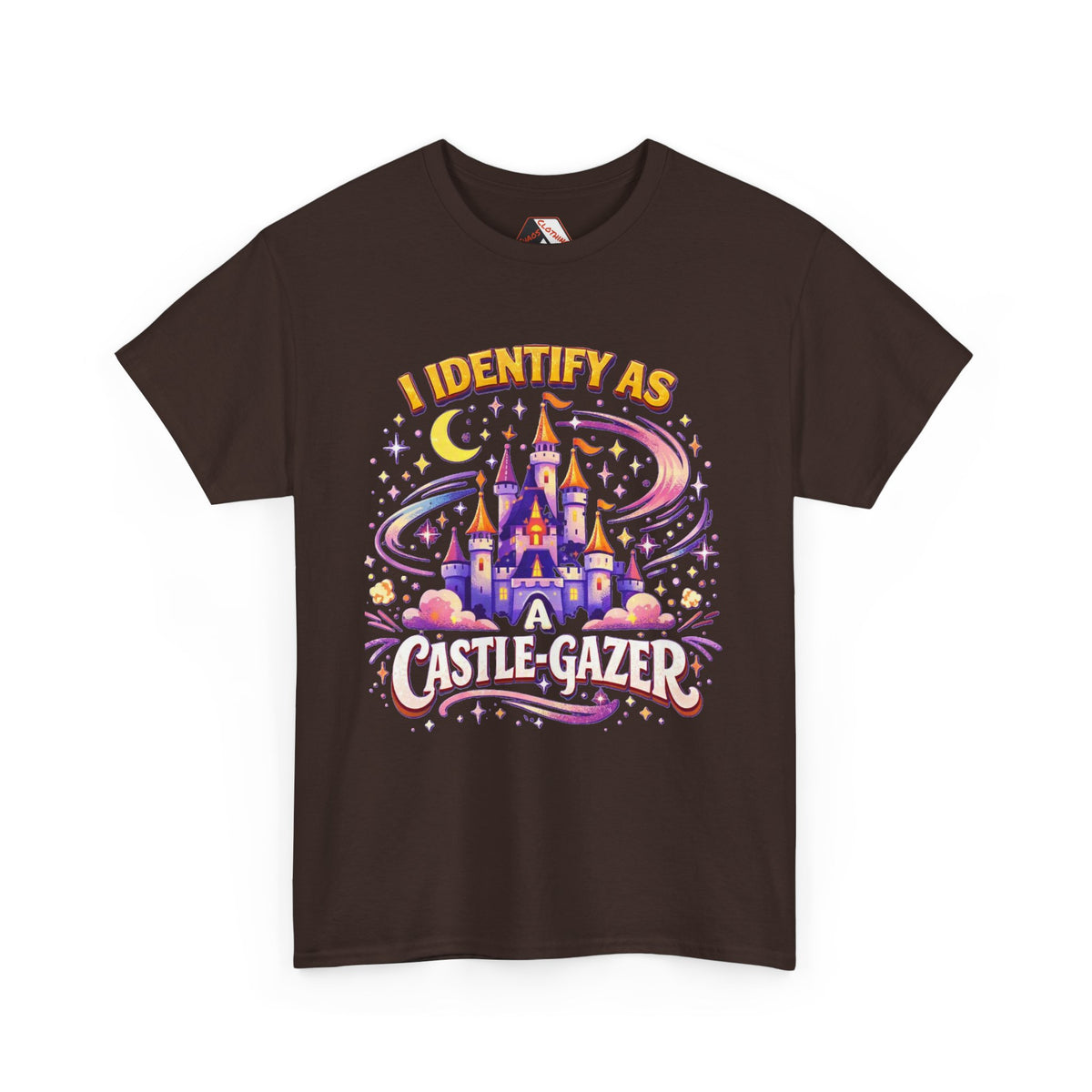 A dark brown short-sleeve t-shirt with a colorful graphic print on the front. The graphic features a whimsical castle under a crescent moon and stars, with the text 'I IDENTIFY AS A CASTLE-GAZER' in stylized fonts.