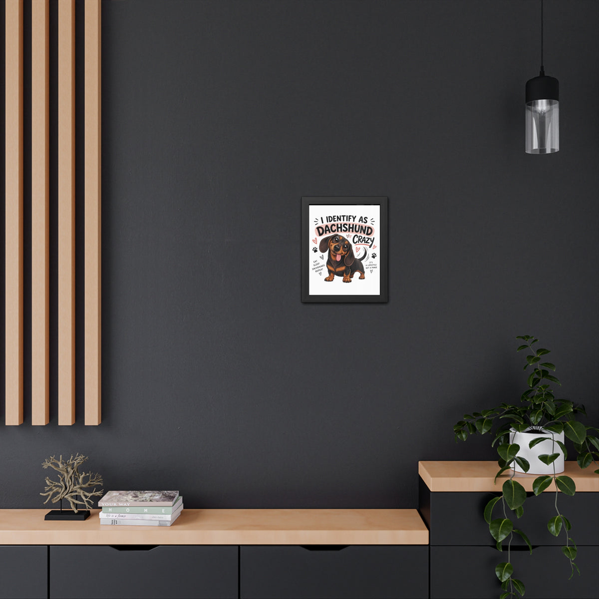 Framed picture of a vintage car on a dark wall with wooden shelves and a plant.