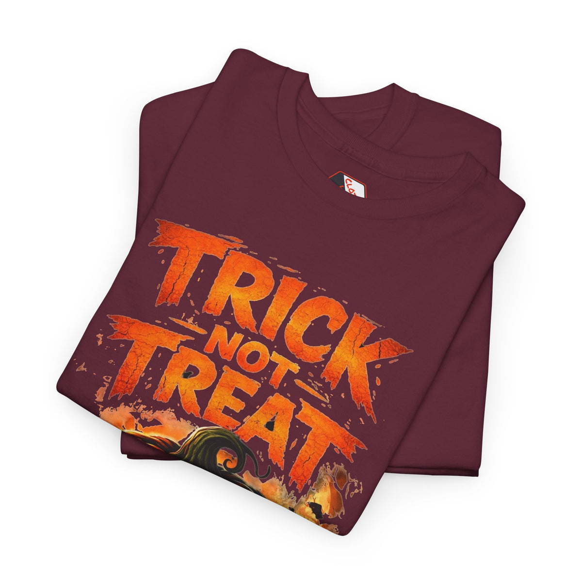 A folded maroon crewneck t-shirt with a distressed orange graphic reading 'TRICK NOT TREAT' and a Halloween-themed print at the bottom, displayed on a clean white background.