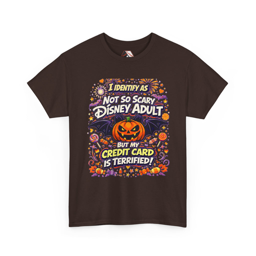 A brown short-sleeve crewneck t-shirt with a colorful graphic print on the front. The graphic features a jack-o'-lantern, bats, candy corn, and fireworks, with the text 'I IDENTIFY AS NOT SO SCARY DISNEY ADULT BUT MY CREDIT CARD IS TERRIFIED!' in stylized fonts.