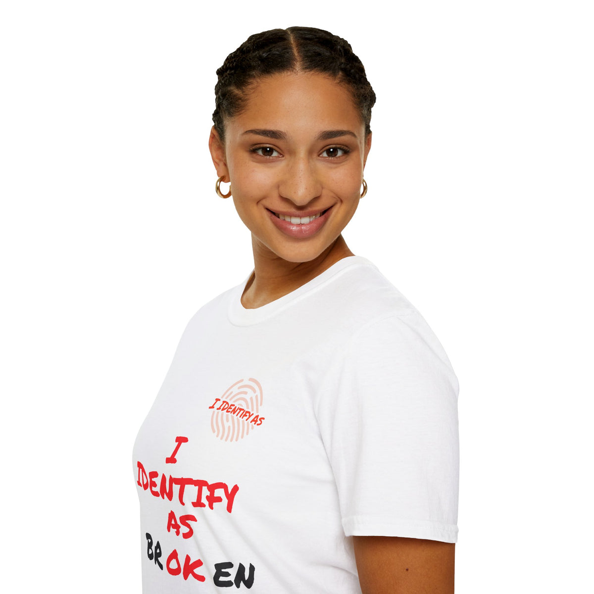 A smiling woman with her hair in braids is shown from the chest up, wearing a white short-sleeve T-shirt with red and black text and a small red fingerprint graphic on the left chest. The background is a clean white studio backdrop. T‑shirt with “I Identify As Broken / OK” dual‑meaning slogan designed in Dartford, UK.