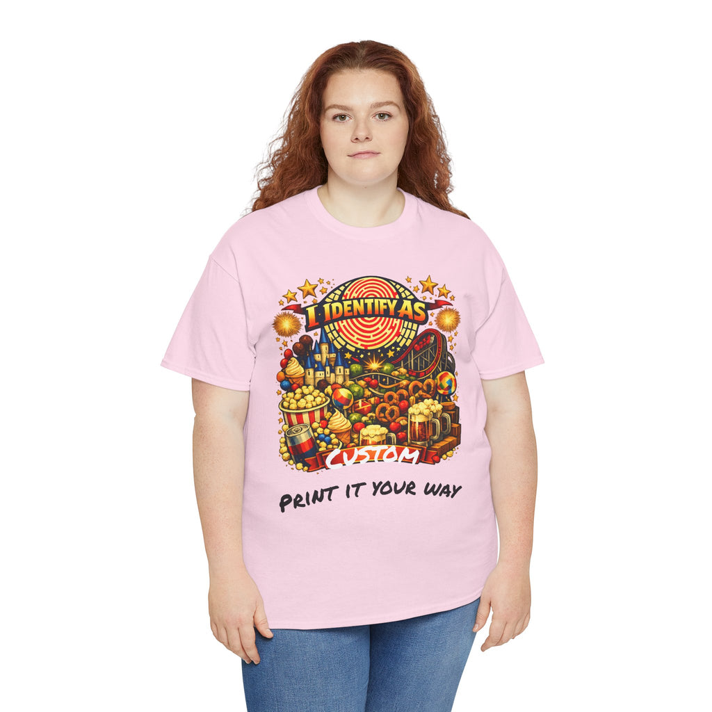 A woman modeling a light pink short-sleeve t-shirt with a colorful graphic print on the front. The graphic features a carnival-themed illustration with the text 'I IDENTIFY AS' and 'PRINT IT YOUR WAY'.