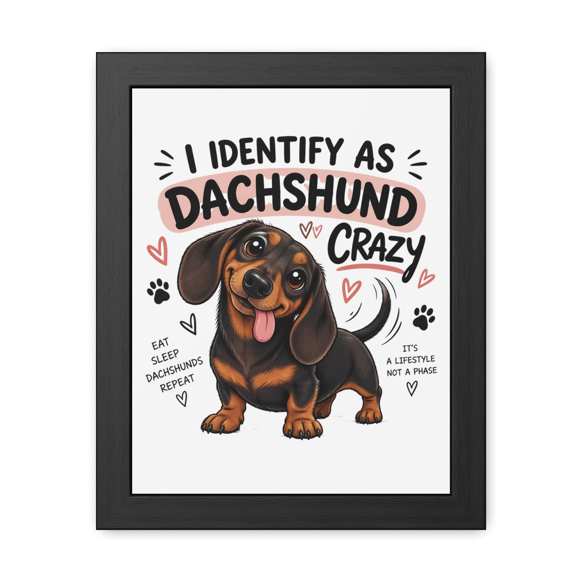 Framed wall art featuring a cartoon dachshund with the text 'I IDENTIFY AS DACHSHUND CRAZY' and smaller phrases around it, shown against a white background with a black frame.