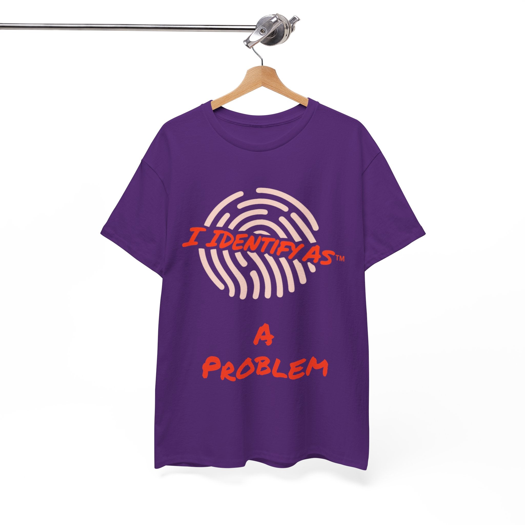 A purple short-sleeve t-shirt hanging on a wooden hanger from a metal rail, featuring a graphic print of a fingerprint with the text 'I IDENTIFY AS A PROBLEM' in red and light pink.