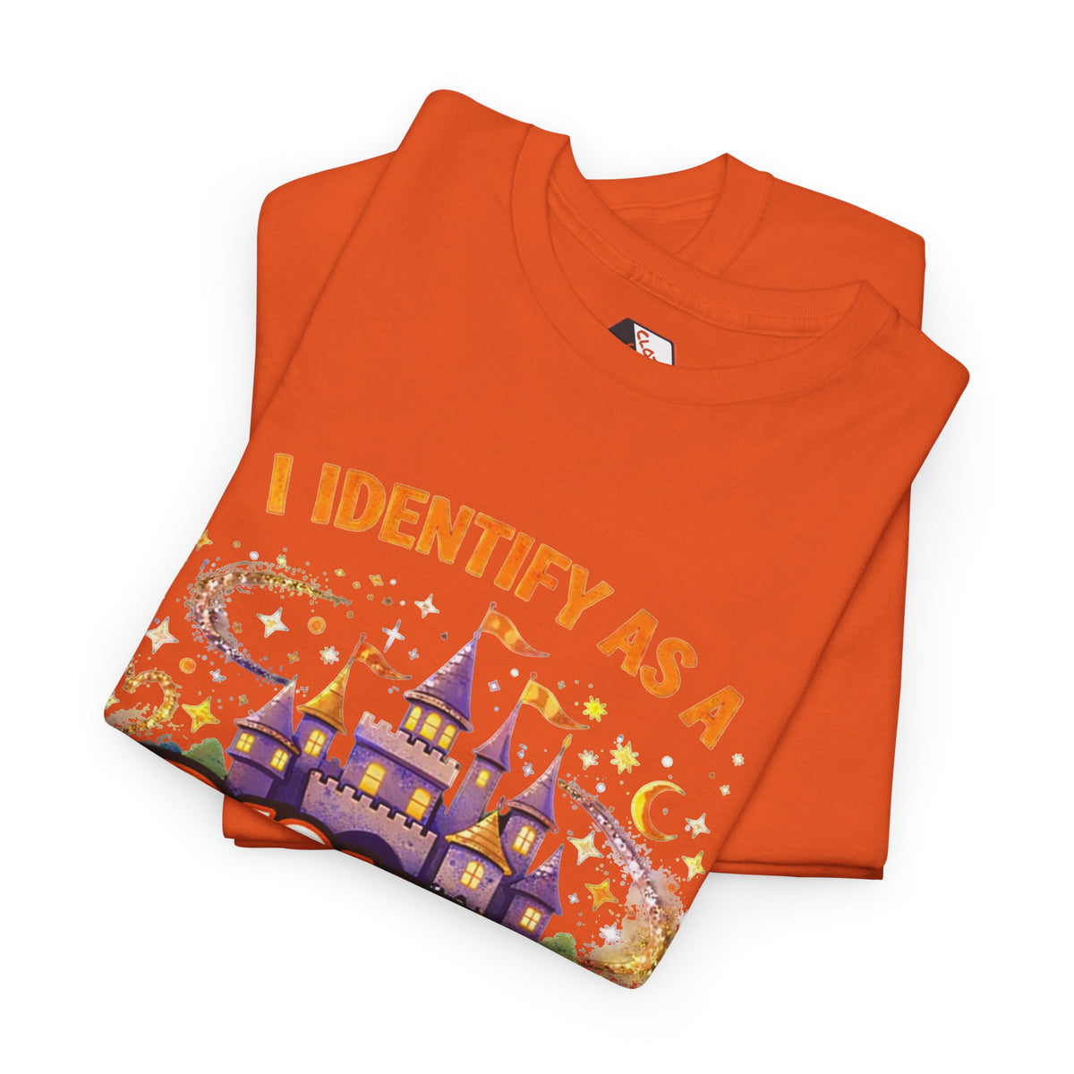 An orange folded t-shirt featuring a graphic of a purple castle under a crescent moon and stars, with the text 'I IDENTIFY AS A' printed in orange above it.