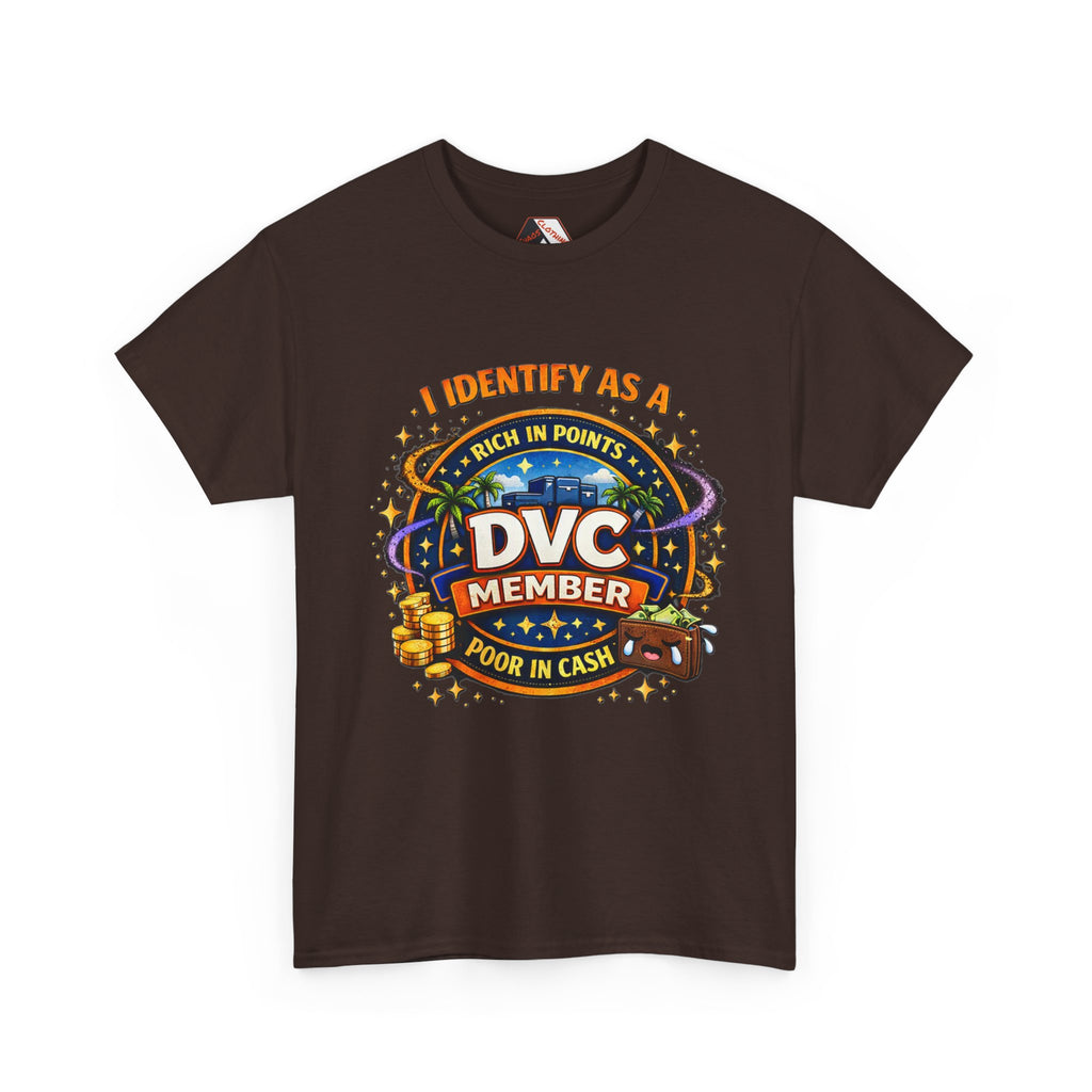A dark brown short-sleeve t-shirt with a colorful graphic print on the front. The graphic features the text 'I IDENTIFY AS A DVC MEMBER POOR IN CASH' in orange and white lettering, surrounded by a parody-style Las Vegas-style casino design with palm trees, a slot machine, and stacks of gold coins.