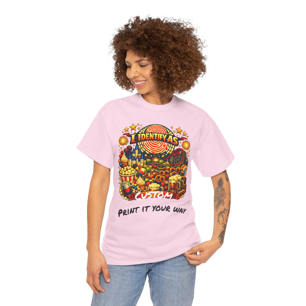 A woman with curly brown hair wearing a light pink graphic t-shirt and blue jeans, standing against a plain white background. The t-shirt features a colorful carnival-themed graphic with the text 'I IDENTIFY AS' above a detailed illustration and 'PRINT IT YOUR WAY' below.