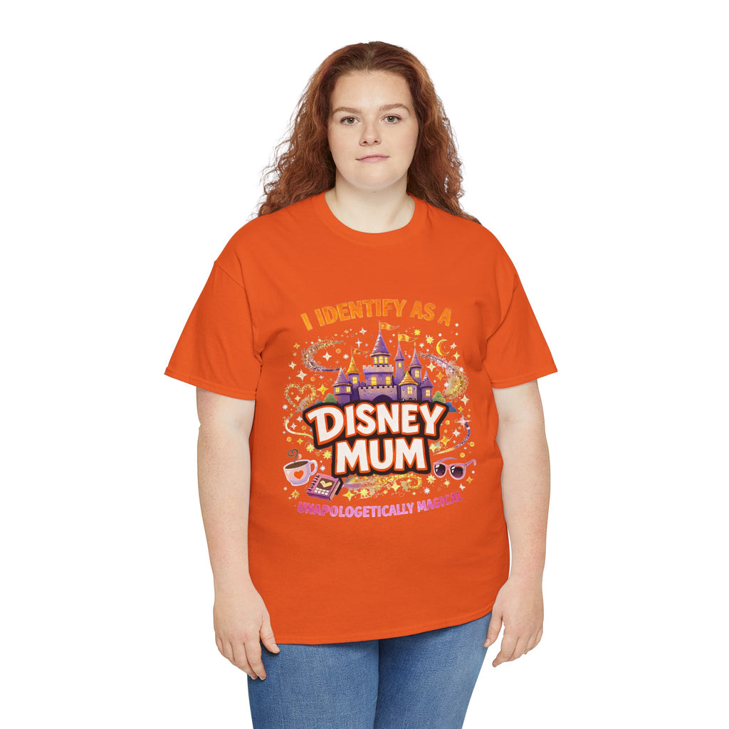 A woman with red hair wearing a bright orange graphic t-shirt that reads 'I IDENTIFY AS A DISNEY MOM' with a colorful castle and parade illustration, paired with blue jeans, against a plain white background.