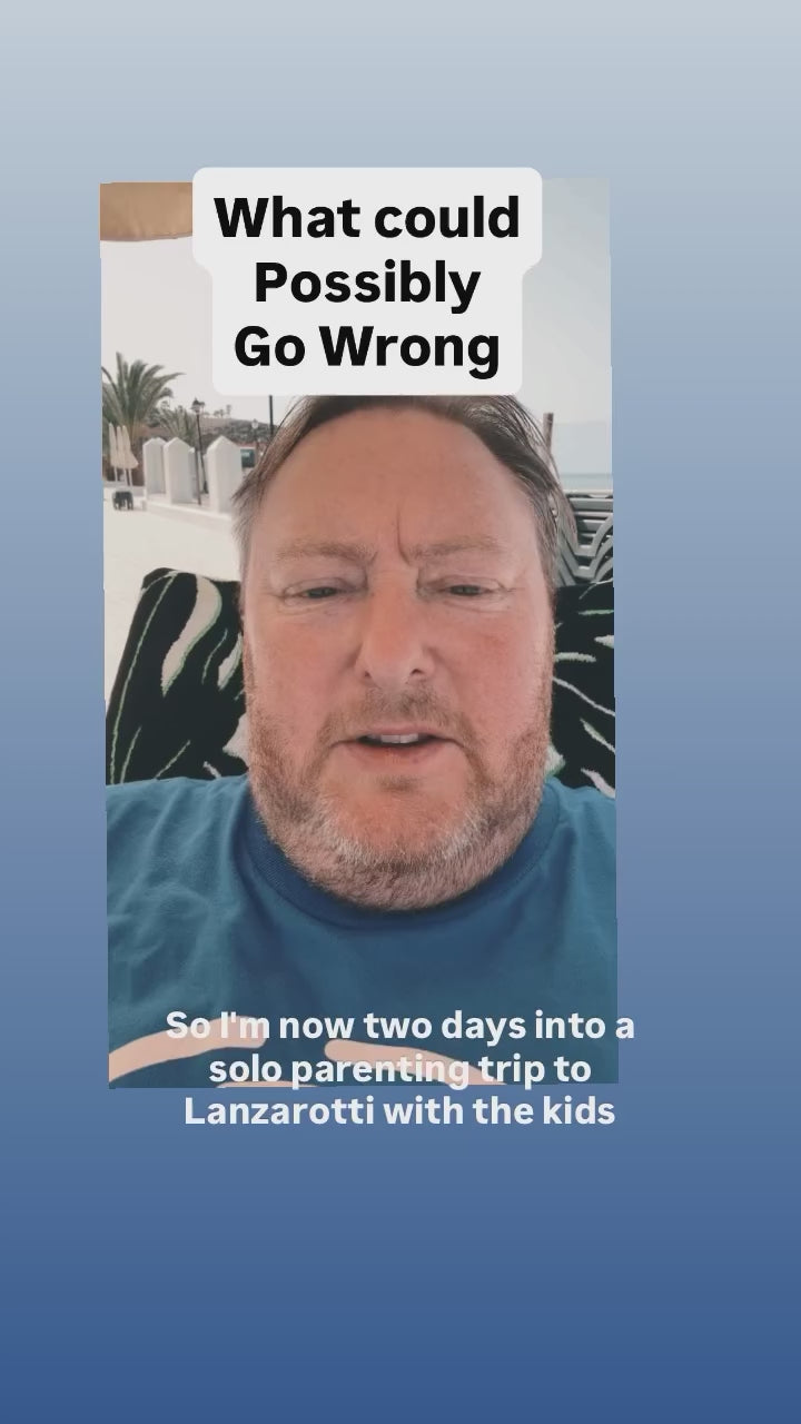Ray, founder of I Identify As, surviving a solo‑parenting trip while wearing the ‘I Identify As The Reason She Drinks’ humour t‑shirt.